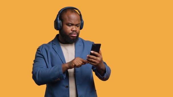 Χαμογελώντας Αφροαμερικανός Ακούγοντας Μουσική Ακουστικά Bluetooth Συνδεδεμένα Smartphone Χαλαρωμένο Άτομο — Αρχείο Βίντεο