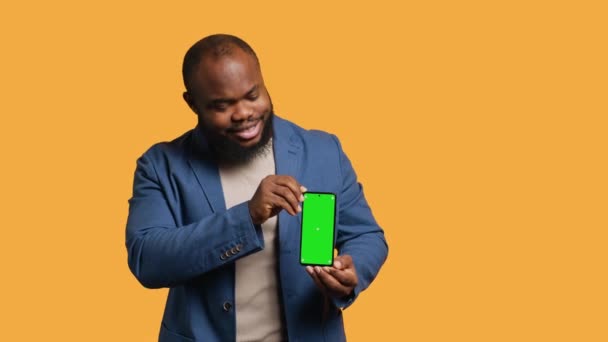 Neşeli Afrikalı Amerikalı Adam Yeşil Ekran Akıllı Telefon Öneriyor Gülüyor — Stok video