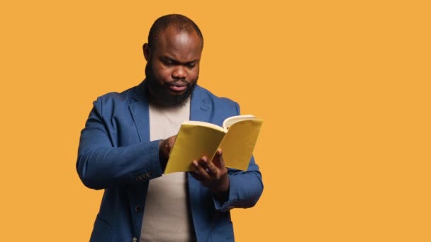 Seorang Pria Berjuang Untuk Membaca Buku Dengan Font Kecil Menunjuk — Stok Video