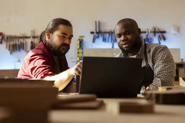 Houtbewerker Bekijkt Blauwdrukken Laptop Brainstormt Met Collega Volgende Stappen Houtverwerking Stockfoto