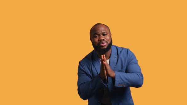 アフリカ系アメリカ人男性がジェスチャーを乞い 願いを叶え イエロースタジオの背景に隔離された 何かを求めているBipocの人 祈りと希望 カメラB — ストック動画