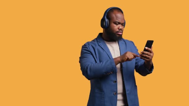 Усміхнений Афроамериканський Чоловік Слухає Музику Навушниках Bluetooth Підключених Смартфона Розслаблений — стокове відео