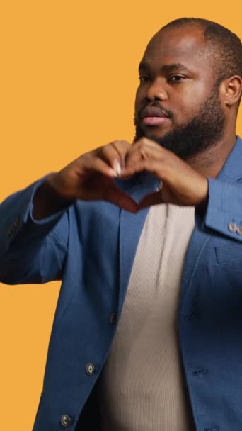 Pionowe Wideo Portret Wesołego Przyjaznego Afrykańczyka Wykonującego Gestem Symbolicznego Serca — Wideo stockowe