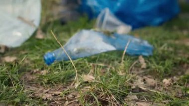 Ormanı çöplerden ve plastik atıklardan temizleyen bir grup gönüllü, uzun pençe ile çöp ve çöpleri topluyorlar. Çevreciler çöpleri topluyor. Kapatın. Kamera A.