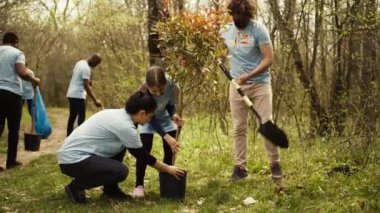 Gönüllülerden oluşan bir ekip, doğa koruma ve koruma için orman çevresinde ağaç dikiyor ve bir koruma projesi için gönüllü olarak çalışıyor. İklim değişikliği eylemcileri tohum ekiyor. Kamera B.