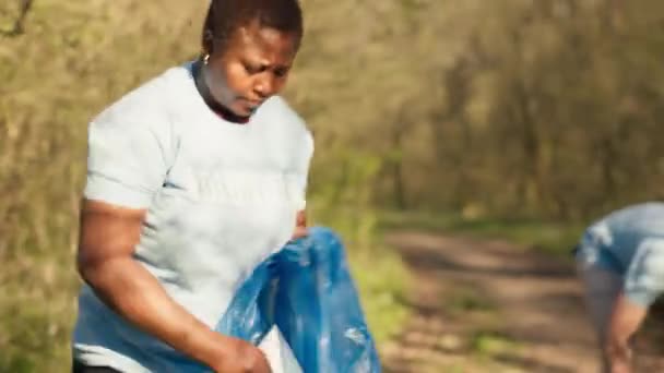 Διάφοροι Εθελοντές Συλλέγουν Σκουπίδια Και Σκουπίδια Από Δασική Περιοχή Καταπολεμώντας — Αρχείο Βίντεο
