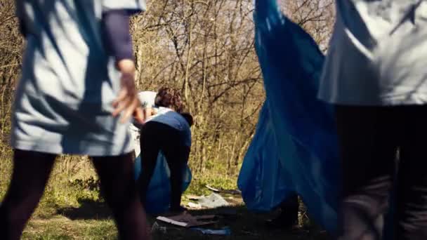 非裔美国女孩用长爪和垃圾袋捡拾垃圾 清理森林栖息地 并与一组志愿者一起打击非法倾倒活动 积极收集垃圾 摄像头B — 图库视频影像