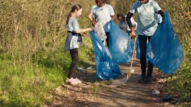 Ormanı çöpten temizlemeye çalışan bir grup gönüllü çöp ve plastik atık topluyor. Çöpleri toplayan ve geri dönüşüm yapan çevreciler ekolojik adaleti destekliyor. Kamera A.
