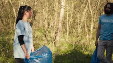 Ormandaki çöp ve çöpleri toplamaya, plastik atıkları ve diğer çöpleri poşetlere atmaya hazırlanan gönüllü gruplar. Çevreciler çöpleri toplayarak doğayı koruyorlar. Kamera A.