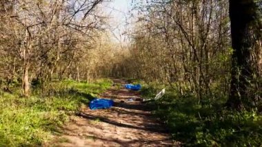 Çöp, plastik atık, orman kirliliği ve yasadışı atıklarla dolu boş orman arazisinin insansız hava aracı görüntüleri. Yürüyüş yolları olan yağmur ormanlarının arka planında bir sürü çöp ve çöp var..