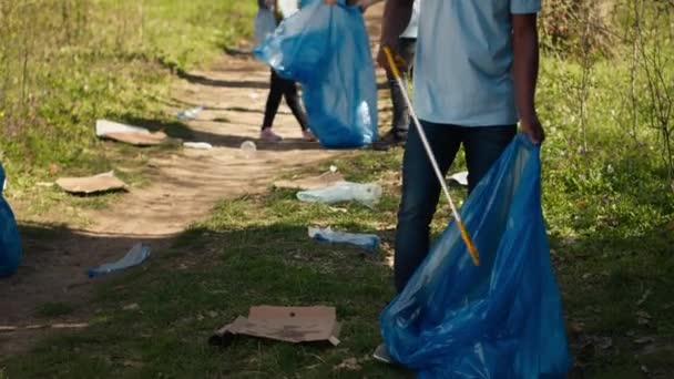 環境にやさしい活動家が森林地帯からゴミやプラスチック廃棄物を集め 森林を掃除しゴミをゴミ袋に入れました 廃棄物管理を担当するボランティア カメラ 動画クリップ