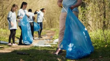 Çöpleri ve plastik atıkları toplamak, çöpleri toplamak ve orman alanını temizlemek için maşa kullanan bir aktivist. Gönüllü olarak çöpleri ayıklıyor ve geri dönüştürüyor, doğayı koruyor. Kamera A.
