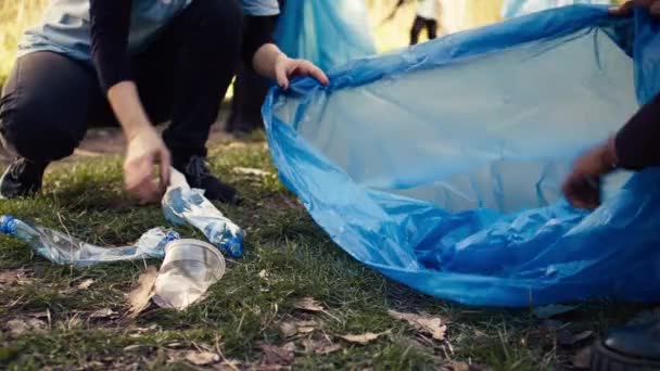 活动人士小组收集垃圾和塑料废物进行循环利用 用垃圾清理工具和垃圾袋清洁森林 人们从森林里捡垃圾 行动主义 靠近点摄像头B — 图库视频影像