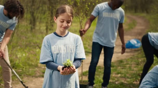 可爱的儿童积极分子手里拿着一棵小树苗 为保护环境和自然生态系统而奋斗 小女孩致力于保护自然和植树 相机A — 图库视频影像