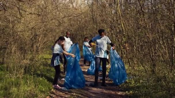 一组志愿者致力于清除森林中的垃圾 收集袋中的垃圾和塑料废物 环保积极分子抓取垃圾和回收利用 支持生态正义 摄像头B — 图库视频影像