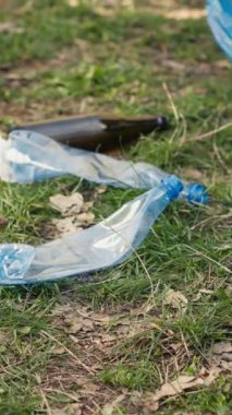 İnsanlar doğal çevrenin temizliğini ormandaki çöp ve geri dönüşümlü nesneleri toplayarak ve çöp torbasında toplayarak destekliyor. Çöpleri toplamak için çatal bıçak kullanmak. Kapatın. Kamera A.