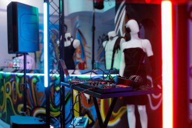 Elektronik müzik şovu ve diskotek partisi için DJ kontrolörü. Müzisyen ses karıştırıcı profesyonel ekipman ve manken kulaklıkla kulüpte hiç insan olmadan.