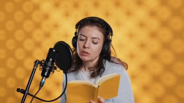 Anlatıcı Kulaklık Takıyor Sarı Arka Planda Kitaptan Mikrofona Yüksek Sesle — Stok video