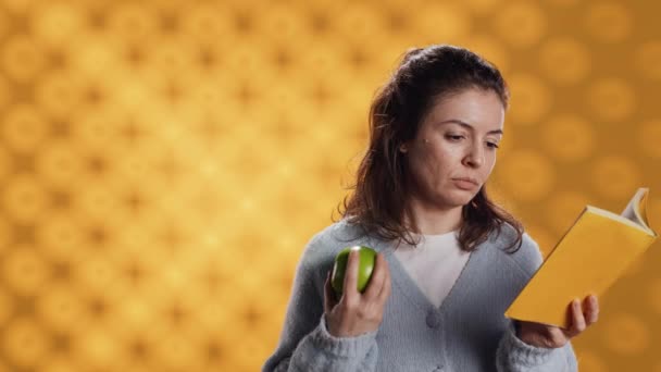 Wanita Membaca Buku Melemparkan Apel Udara Untuk Melatih Otot Lengan — Stok Video