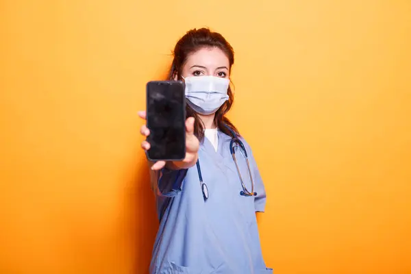 Nurse Wearing Scrubs Face Mask Gripping Cell Phone Blank Screen — Stock Photo, Image
