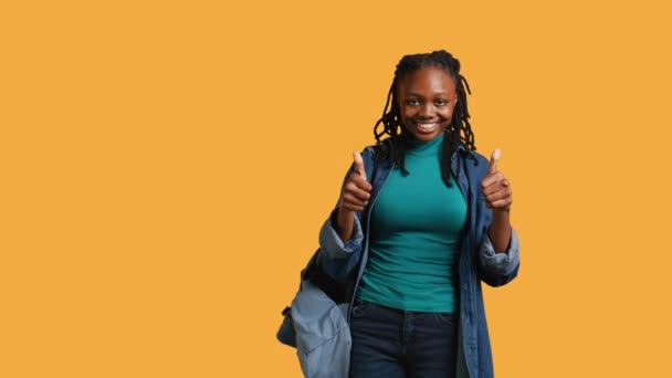 快乐的女孩竖起大拇指做手势 表示赞同 有积极的心情 微笑着的非洲裔美国青少年展示确认书 签署协议书 工作室背景 相机B — 图库视频影像