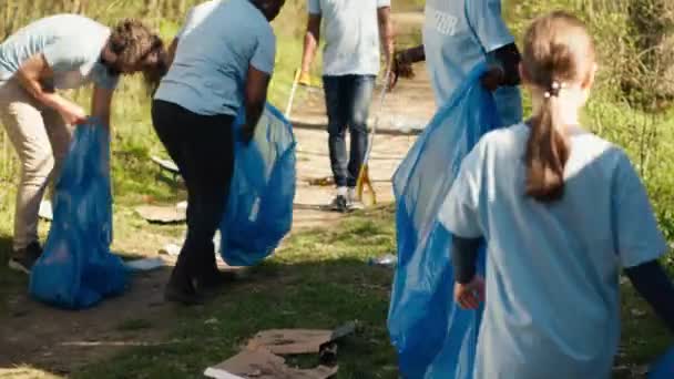 Afroamerikanisches Mädchen Sammelt Mit Einer Langen Kralle Und Müllsäcken Müll — Stockvideo