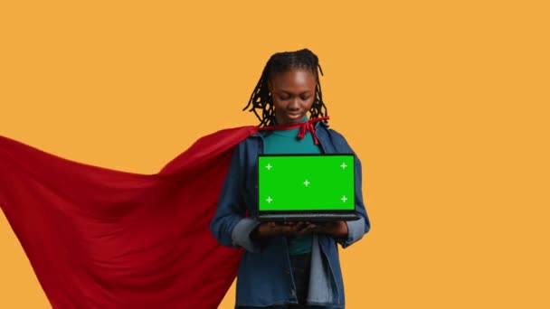 Portret Kobiety Bipoc Portretującej Superbohatera Peleryną Prezentującą Odizolowany Laptop Ekranowy — Wideo stockowe