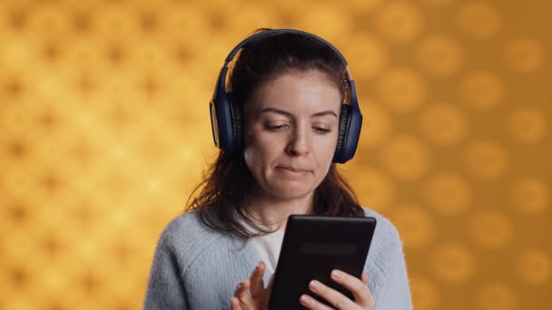 Kulaklık Takan Bir Kadın Dijital Tablette Internet Uygulaması Kullanarak Yeni — Stok video
