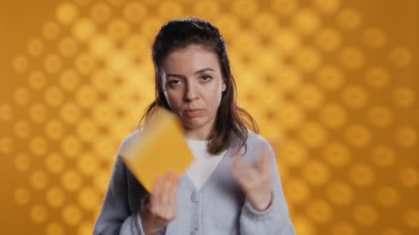 失望した女性が本をぶち壊し スタジオの背景の上に隔離された親指のサインを示した 新しい小説に不満を抱き 否定的なレビュー カメラBを与える — ストック動画