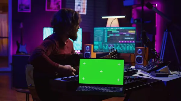 Гітарист Грає Акустичному Інструменті Поруч Зеленим Екраном Ноутбуці Вивчаючи Нові Стокова Картинка