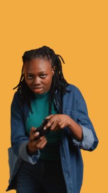 Ekrandan maç izledikten sonra hayal kırıklığına uğramış genç bir kız görüntüsü var. Kadın video oyunu kaybettikten sonra üzgün, oyun alanı ile oynuyor, stüdyo arka planı, kamera B