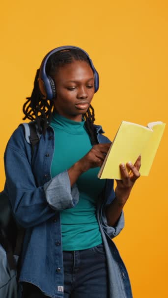 Vertical Video Young Girl Wearing Headphones Reading Interesting Book Enjoying — Stock Video