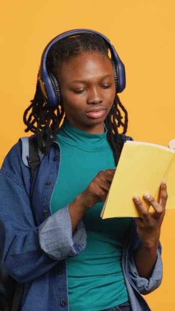 Pionowe Wideo Młoda Dziewczyna Nosi Słuchawki Czytając Ciekawe Książki Ciesząc — Wideo stockowe