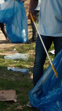 Çevre dostu eylemci bir orman bölgesinden çöp ve plastik atık topluyor, ormanı temizliyor ve çöp torbasında çöp topluyor. Atık yönetimiyle uğraşan gönüllü bir adam. Kamera A.