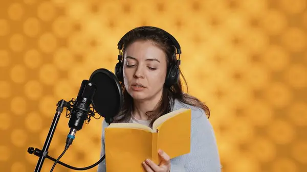 Narrator Wearing Headset Reading Aloud Book Mic Yellow Background Upbeat — Stock Photo, Image