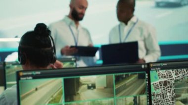 Trafiği izlemek için CCTV izleme sistemi kullanan çeşitli çalışanlar. Uydu radar sistemi aracılığıyla halkın güvenliği için hız limitlerini takip ediyorlar. Kontrol merkezindeki büyük ekranda çalışan insanlar. Kamera A
