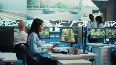 Hintli kadın operatör teslimat kamyonunun yerini belirliyor ve sevkiyat yerinin GPS koordinatlarını veriyor. Kontrol Merkezi çalışanı güzergahlar için uydu haritası ve CCTV sistemine danışmanlık yapıyor. Kamera B.