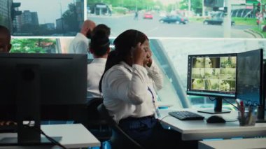 Afrika kökenli Amerikalı çalışanlar, güvenlik için CCTV sistemini kullanarak şehirdeki trafiği izliyorlar. Kadın, devlet gözlem odasında gerçek zamanlı güvenlik kamerası görüntülerini izliyor. Kamera B.