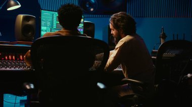 Ses uzmanı ve müzisyen, stüdyodaki kontrol odası konsolunun parçalarını karıştırıyor ve ustalaştırıyor, müzik sonrası prodüksiyonda melodileri kaydediyor ve düzenliyor. Yetenekli bir sanatçı ve ses mühendisi. Kamera B.
