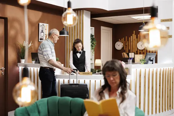 Recepciós Segít Időseknek Bejelentkezni Amikor Megérkezik Hotel Recepciójára Míg Idős Stock Fotó