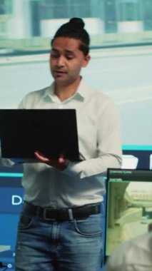 Dikey Video Hindistanlı takım lideri, güvenlik sistemi üzerinden kentsel güvenlik görüntülerini izlemek için ekibini koordine ediyor. Devlet dairesi çalışanları uydu üzerinden trafiği izliyor