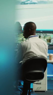 Dikey Video Çeşitliliği çalışanları şehir trafik dinamiklerinde düzensizlikler bulmak için gerçek zamanlı güvenlik kamerası görüntülerini inceliyor. Kurum çalışanları CCTV sisteminde video izliyorlar.