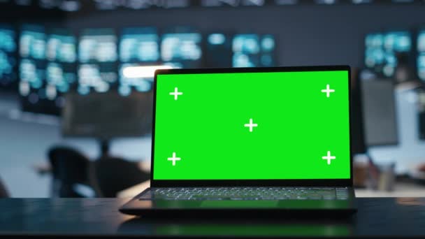 将注意力集中在服务器室内的绿色屏幕笔记本电脑上 这种笔记本电脑被模糊背景的人用来保护数据不受威胁 保护超级计算机的专业人员使用的彩色密钥笔记本电脑的近照 — 图库视频影像
