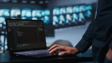 Bilgi işlem çalışanı veri merkezinde en iyi performansı sağlamak için dizüstü bilgisayarda klavye kullanıyor. Sunucular arasında enerji tüketimini izleyen işçilerin kullandığı dizüstü bilgisayarın yakın plan görüntüsü