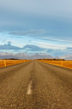 İzlanda 'nın ıssız yollarında karla kaplı dağlar, buzlu tarlalar, kırsal yol. İskandinav tepeleri ve İskandinav doğası ile İzlanda 'da muhteşem uzun bir yol..