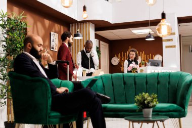 İş adamı formaliteleri kontrol etmeye başlıyor, otel resepsiyonistleriyle kibarca selamlaşıyor. Şirket çalışanı odayı görmek ve gelecek toplantılara hazırlanmak için sabırsızlanıyor..