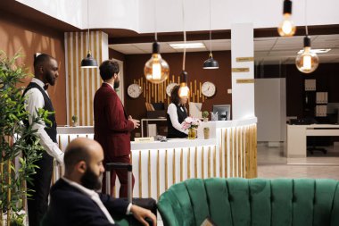 Otel personeli, yürütme konferansına katılmak üzere seyahat eden işadamlarına lüks hizmetler sunuyor, resepsiyon lobisinde. İş seyahati, girişimci resepsiyona kayıt yaptırıyor..