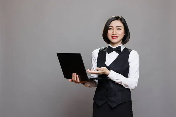 Smiling Asian Waitress Professional Uniform Showing Laptop Looking Camera Resepsionis Stok Gambar Bebas Royalti