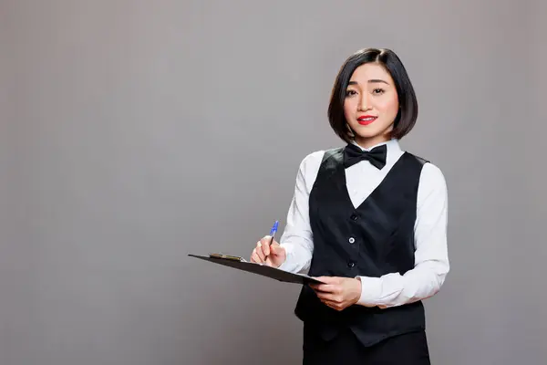 Joven Camarera Asiática Uniforme Sujetando Portapapeles Escribiendo Orden Del Cliente Fotos De Stock Sin Royalties Gratis