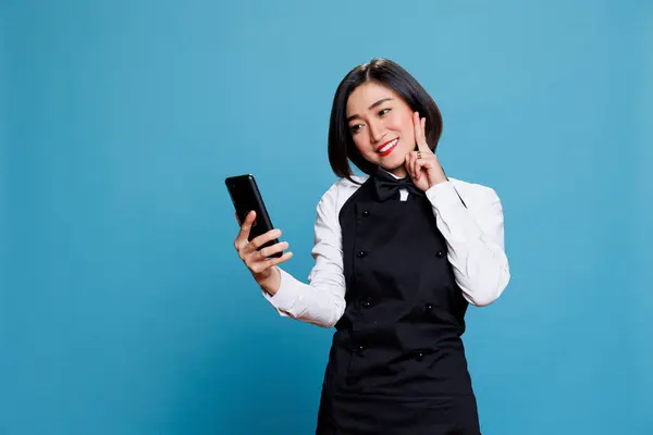 Wesoła Azjatycka Recepcjonistka Pokazuje Gest Pokoju Palcami Podczas Rozmowy Smartfonie Zdjęcia Stockowe bez tantiem